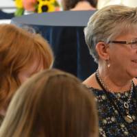 Three alumnae enjoying conversation at a table